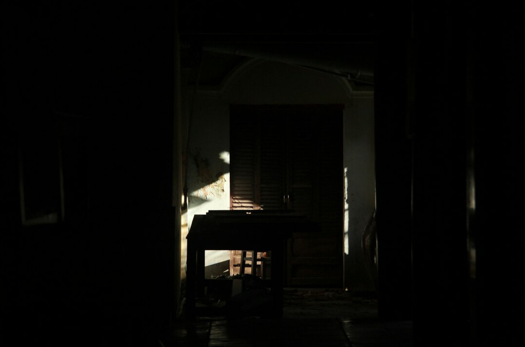 shadowy figures meeting in dark room